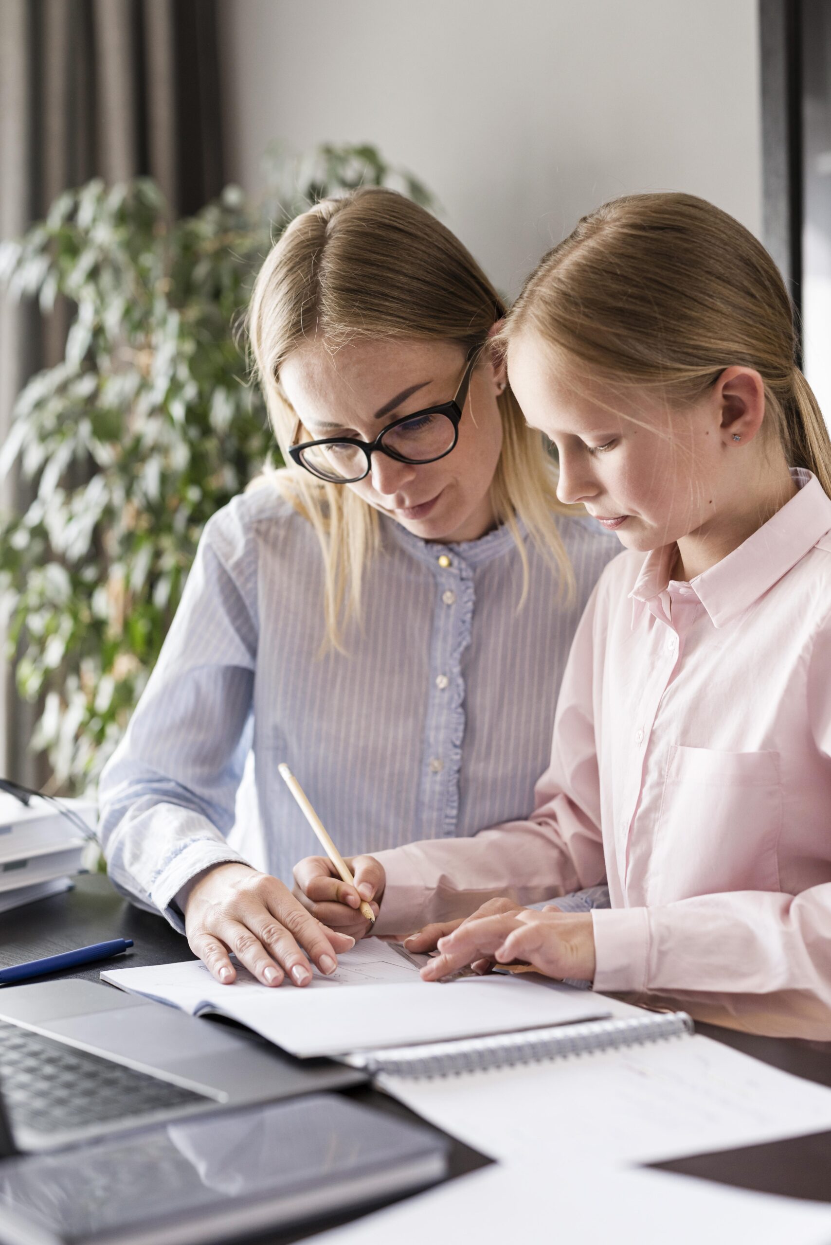 woman helping young girl with homework